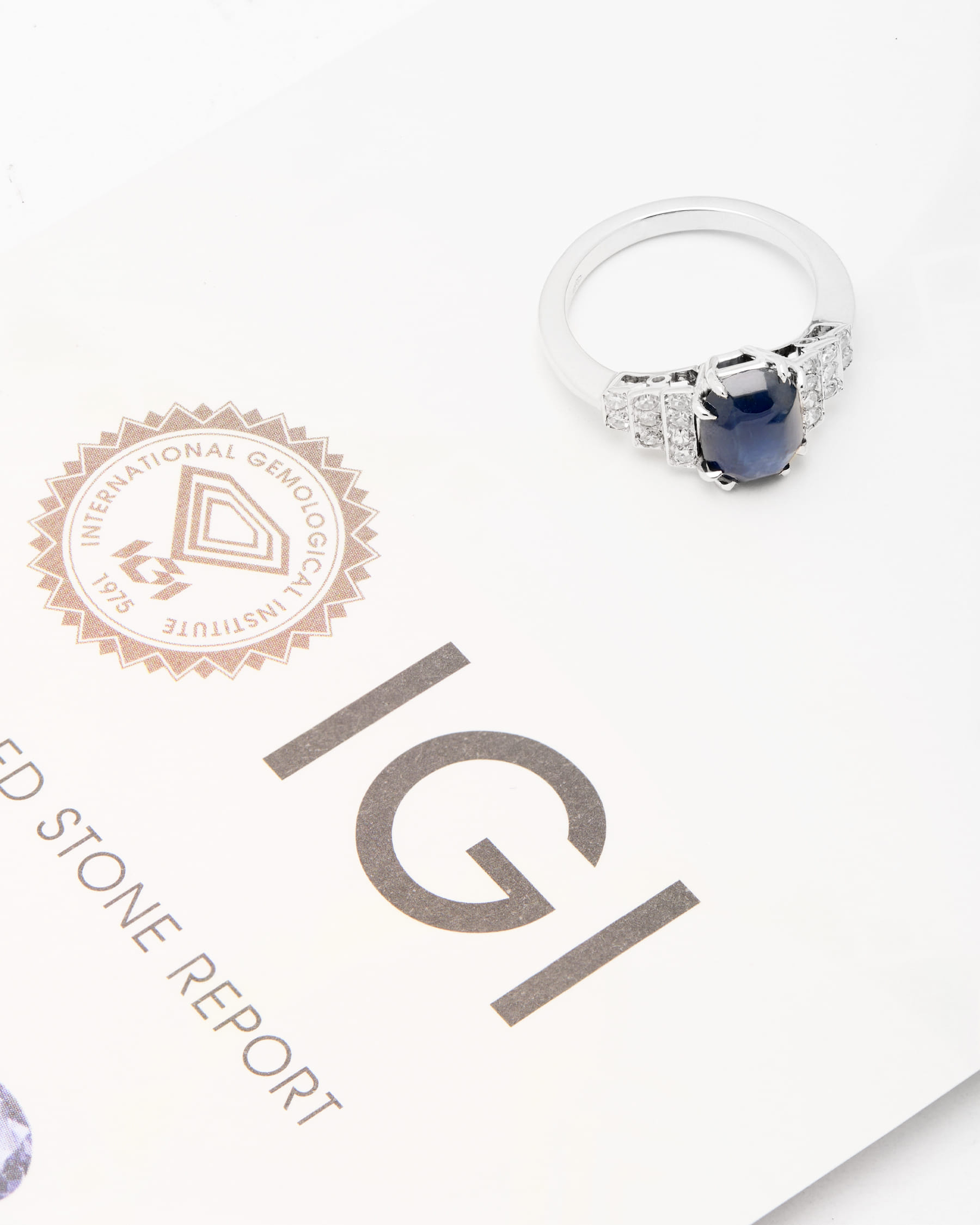 Anello in oro bianco con zaffiro centrale cuscino cabochon con gradini laterali di diamanti-4